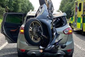 Motorcycle embedded in back of car in crash